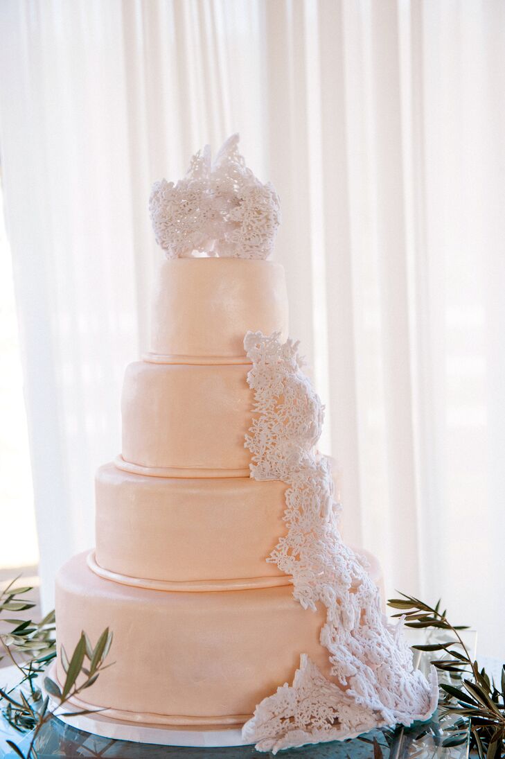 The four-tier classic wedding cake had no additional decor besides sugar lace that trailed down the sides and sat on top of the dessert. Alyssa's wedding dress lace overlay served as the inspiration behind the lace accents on the cake.