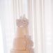 The four-tier classic wedding cake had no additional decor besides sugar lace that trailed down the sides and sat on top of the dessert. Alyssa's wedding dress lace overlay served as the inspiration behind the lace accents on the cake.
