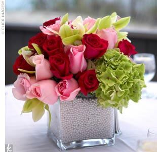 To make the centerpiece blooms even more striking, the couple’s florist created pink and green arrangements in square glass vases and filled them with white pearls so the stems weren’t visible. White votive candles were also scattered around each table to set the romantic mood, and the brightly colored flowers popped against the all-white linens.