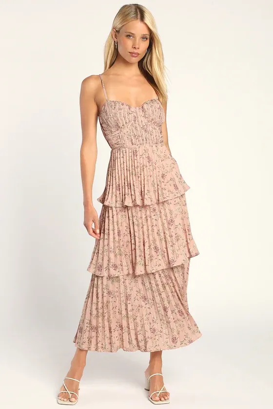 Model wears a blush pink bridesmaids dress with a romantic floral pattern. 