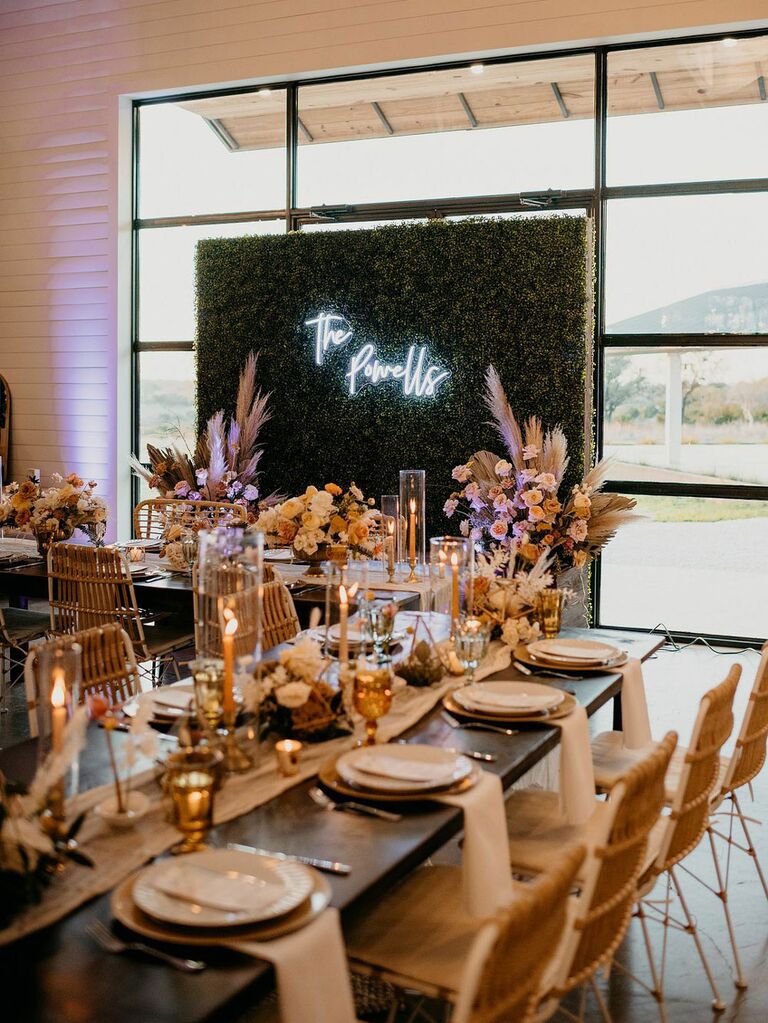 Greenery wall with custom neon sign at modern bohemian wedding reception