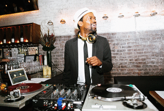 DJ smiling while playing music at a wedding.