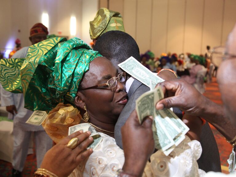 Couple engages in a traditional Nigerian money dance. 