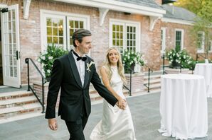 Groom in Classic Tuxedo, Calla Lily Boutonniere and Bride in High-Neck, Silk Gown Walking into Reception