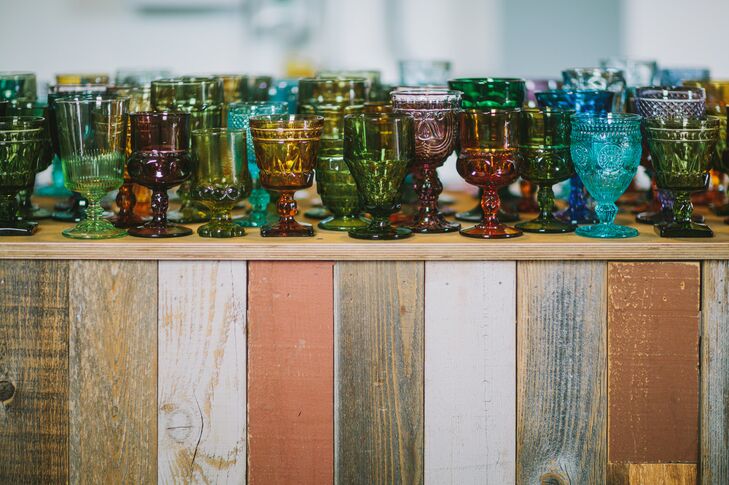 Guests enjoyed their drinks out of eclectic vintage colored glass glassware to match the shabby chic, bohemian feel of the wedding.