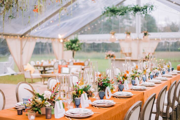 Rustic Tented Wedding Reception With Orange Linens and Blue Water Goblets