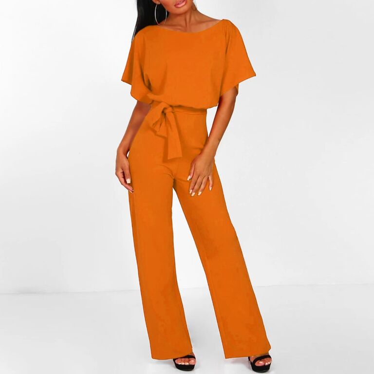 Model wearing orange jumpsuit with ruffle short sleeves and a belt around the waist
