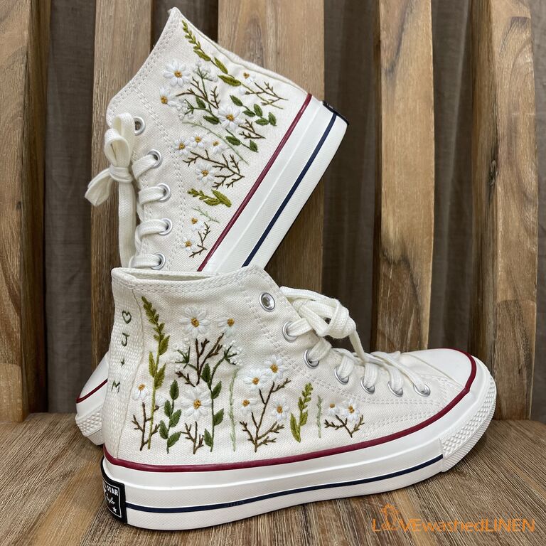 White converse shoes embroidered with leaves, stems, and daisies from Etsy