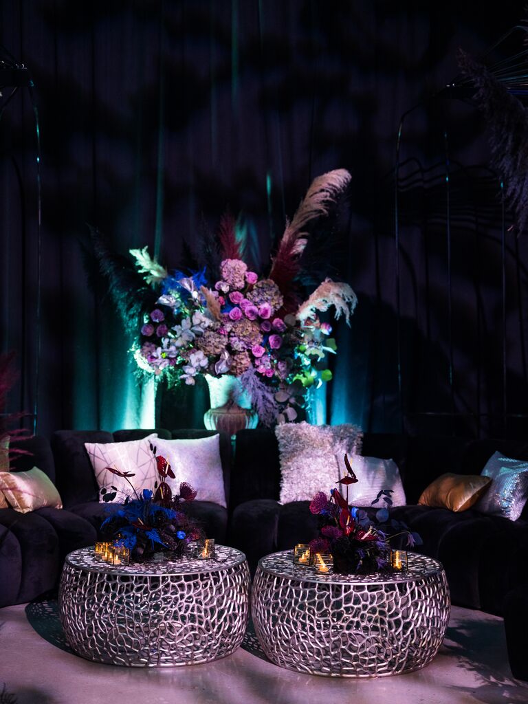 wedding lounge with abstract flower arrangements in moody color palette of black, purple and blue