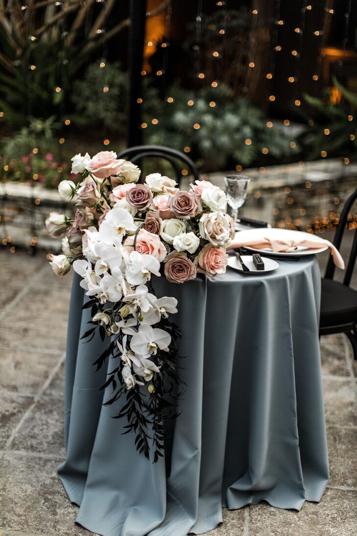Sweetheart Table With Blue Linen and Dramatic Floral Arrangement