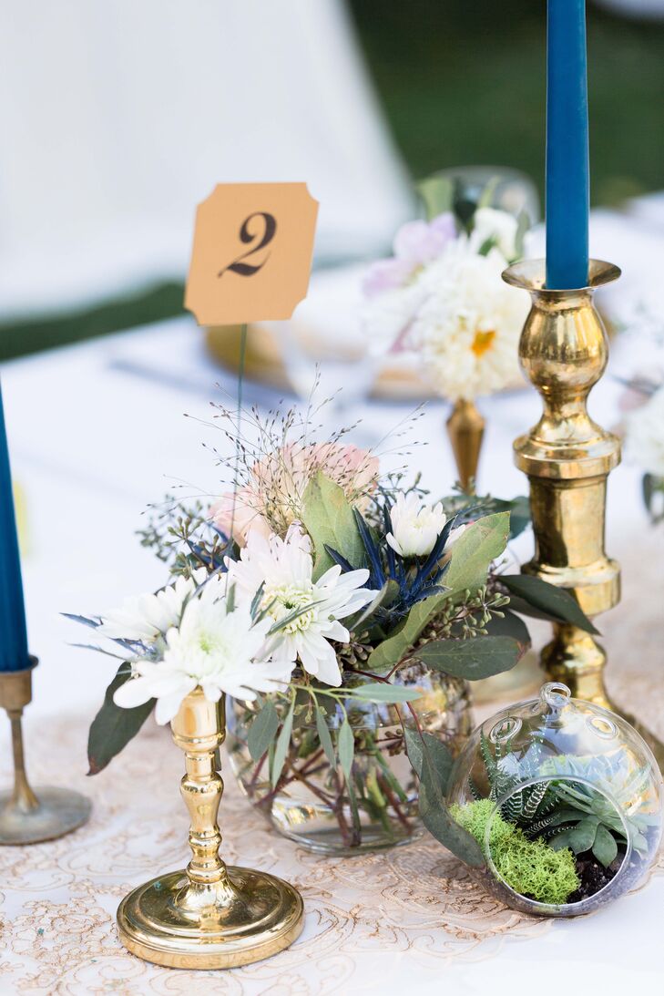 “Annie and her mom spent a weekend filling tiny glass orbs with soil, succulents, moss and flowers, which were displayed along the center of the tables,” the couple says. “They collected brass candlesticks in which they filled half with bouquets of the same flowers used in the bouquets and the other half with dark teal taper candles.”