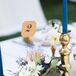 “Annie and her mom spent a weekend filling tiny glass orbs with soil, succulents, moss and flowers, which were displayed along the center of the tables,” the couple says. “They collected brass candlesticks in which they filled half with bouquets of the same flowers used in the bouquets and the other half with dark teal taper candles.”