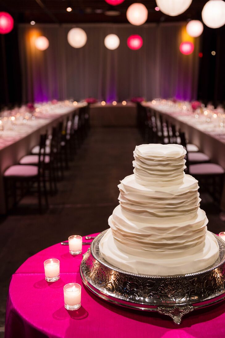 The three tier white wedding cake had romantic fondant ruffles.