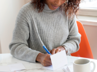 Writing wedding wishes in a wedding card to say congratulations