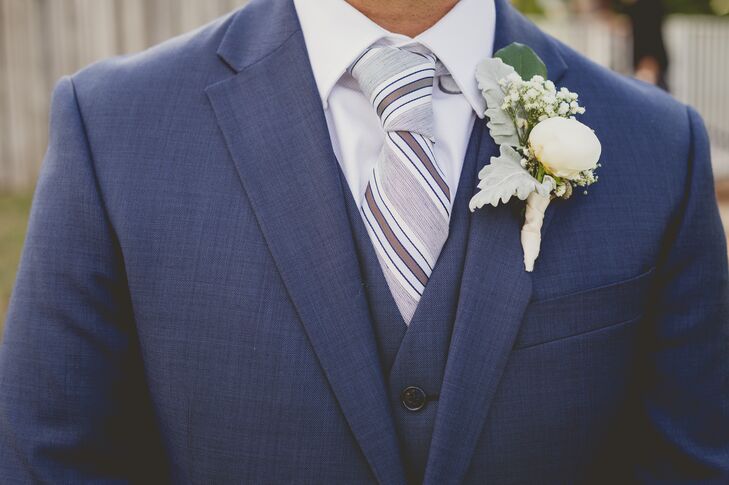 After selecting a dapper, three-piece navy suit, Rodney completed the look with few standout accessories. He wore a white shirt, a grand white peony and dusty miller boutonniere and a striped blue and white tie that brought it all together.