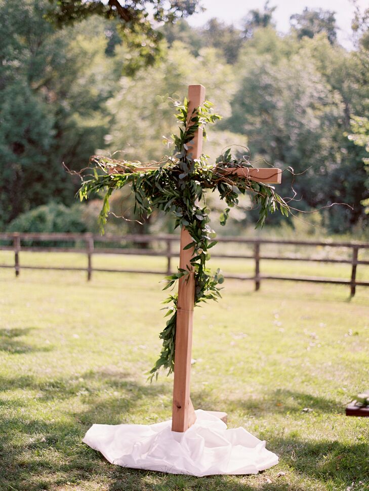 To distinguish the ceremony altar, Kristina's father handmade a wooden cross, which was then draped with olive leaves and vines to complement the ceremony's natural setting.