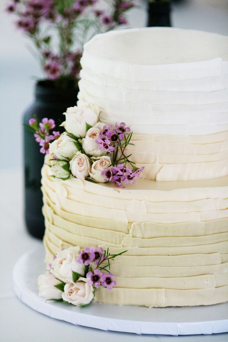 The couple's two-tier six- and nine-inch round ombre cake used white frosting on top and champagne icing on the bottom. "The top was raspberry swirl cake with a buttercream filling and the bottom was chocolate cake with a peanut butter filling," Ashley says. "Our florist had light purple spray roses and purple wax flowers set aside to decorate the cake."