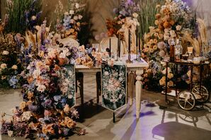 Reception Table Covered in Embroidered Table Runner and Lush Flower Arrangements