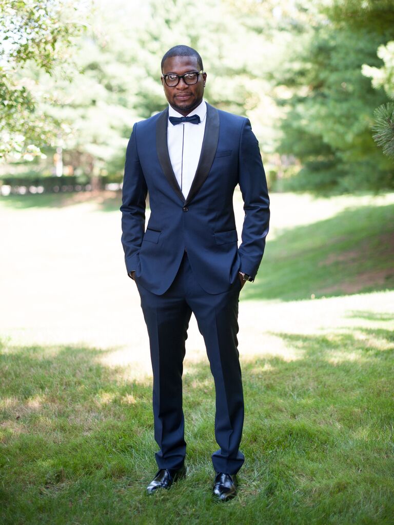 groom standing outdoors wearing dark blue tuxedo