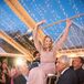 Woman in a Pink Dress Lifted in a Chair During Hora at Jewish Wedding