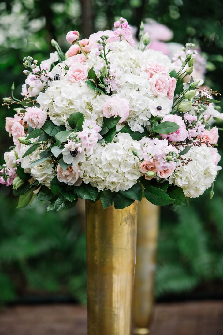 The ceremony aisle was framed with four gold vases filled with pink roses and peonies and white hydrangeas and anemones.