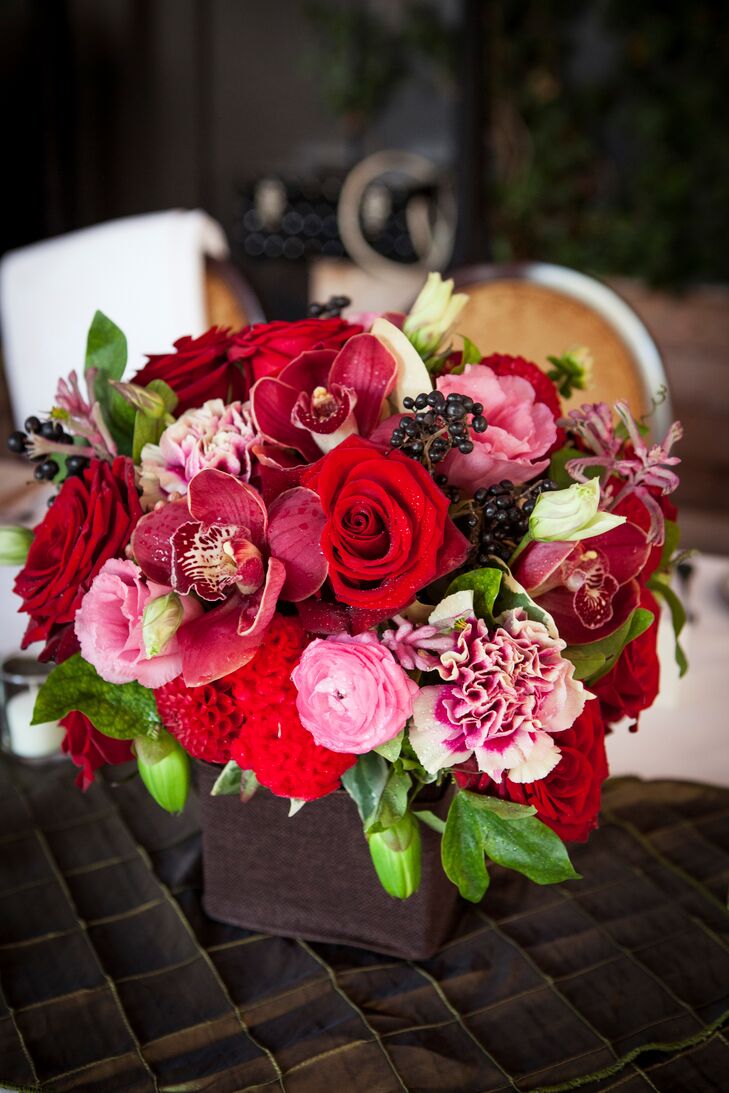Victoria Ahn Designs by Ahn took Stanley and Jason’s vision for a masculine yet romantic aesthetic and transformed it into reality, creating a series of low arrangements with fresh dahlias, orchids, roses and ranunculus in deep shades of red, pink and navy. The centerpieces popped against the elegant gold and white linens, injecting life and energy into the chic decor.