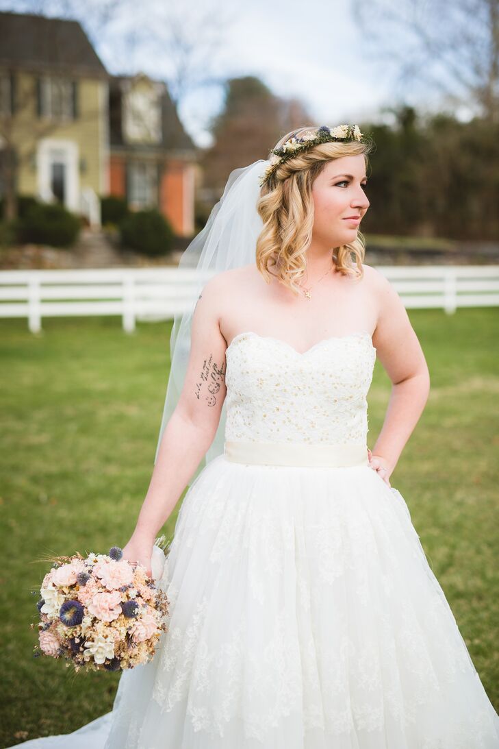 Marianne bought her wedding dress from preownedweddingdresses.com. "We were pretty laid-back about wedding day fashion," she says. She ended up with a stunning Alita Graham ball gown that had sparkly gold beading in the bodice and intricate lace details in the skirt. To complete the look, she wore her hair naturally with a flower crown that matched her bouquet along with an elbow-length veil.