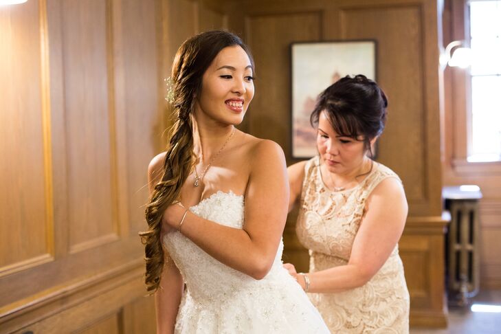 Denise's long hair tied into a side ponytail fell to her right side, right next to the elegant silver necklace that dangled right above her strapless wedding dress.