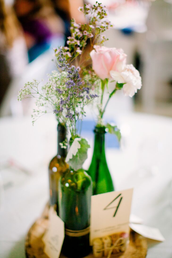 In the months leading up to the wedding, Bethany collected wine bottles that would later make up their simple centerpieces.  “Our friends would drop off empty wine bottles at my house, and I cleaned nearly 200 of them!" she says. To put them together, they tied the bottles together with twine and displayed them on wood slabs from a tree that fell in Bethany’s dad’s backyard.