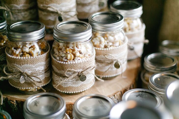 Katharine and Marc's favors were DIY mason jars filled with homemade caramel popcorn. Katharine made the popcorn, while her mother helped decorate the mason jars in burlap and lace with a little "love" charm.