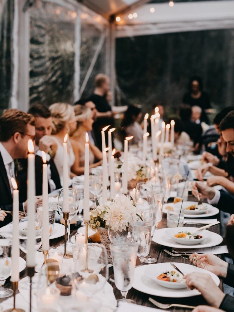guests sitting at table with taper candles