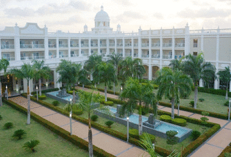 Aerial view of a white hotel with palm trees