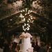 Three-Tier White Wedding Cake With Live Pink Flowers and Sequined Linen