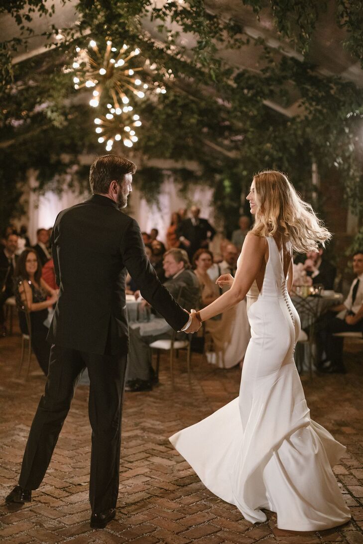 Classic Bride and Groom Doing First Dance Under Tent With Hanging Greenery