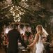 Classic Bride and Groom Doing First Dance Under Tent With Hanging Greenery