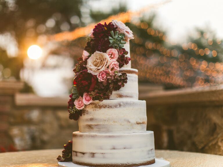 four-tier naked buttercream wedding cake with fall flowers in burgundy, pink and ivory colors