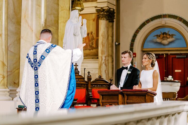 Bride and Groom Kneeling at the Altar During Catholic Mass at Religious Wedding