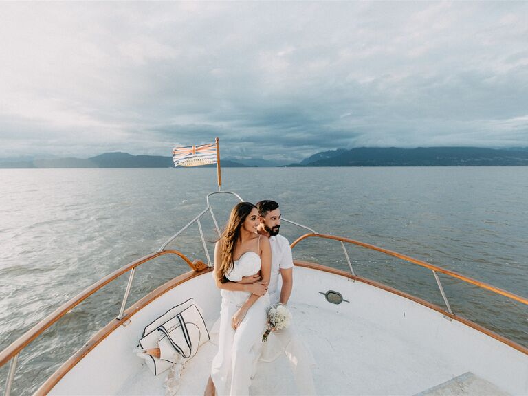 A couple stare out over the water in the yacht engagement photoshoot