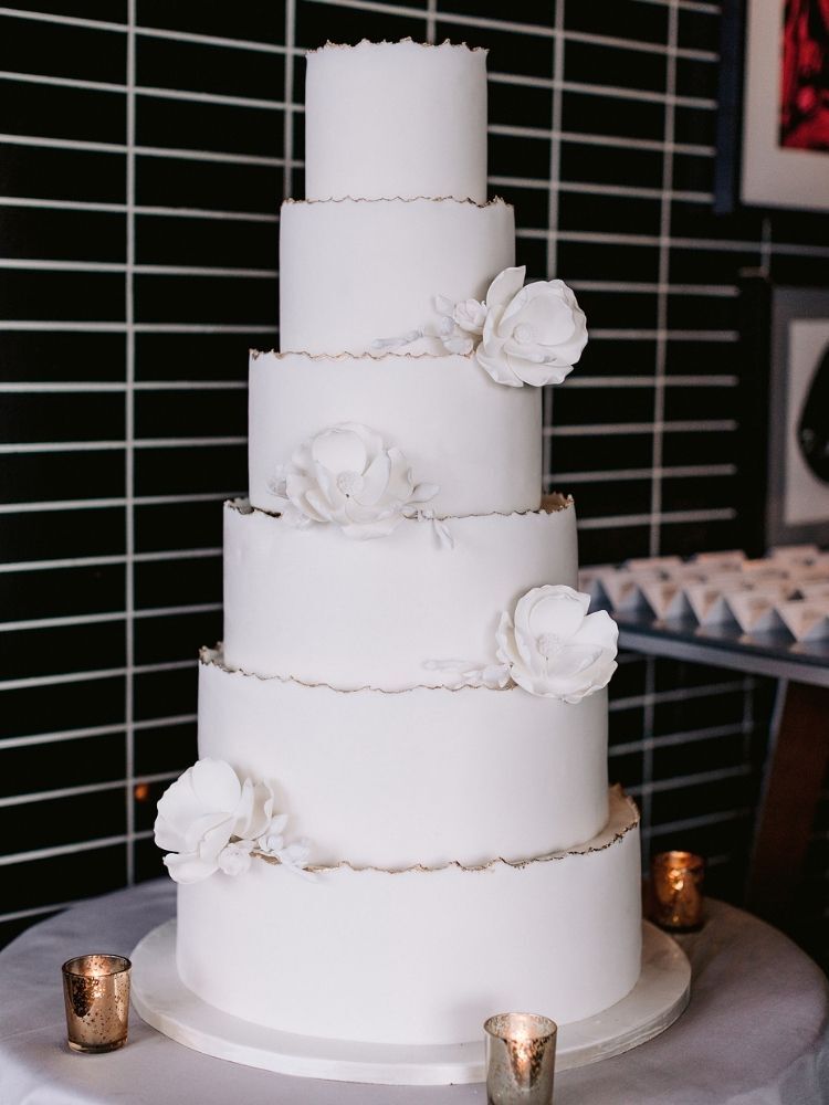 six-tier white wedding cake with sugar flowers