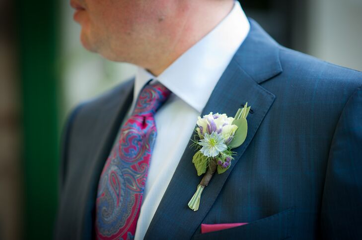 James and Stephen wore suits instead of tuxedos. Stephen wore a blue-gray suit with a red and navy paisley tie and a matching red pocket square. He pinned a purple and white boutonniere to his lapel to complete the look.