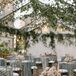 Tented Outdoor Reception With Hanging Greenery and Small Tables With Candles