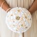 Showing off the day’s vintage style, each bridesmaid paired her dress with handmade fabric bouquet. Rose-inspired blooms in champagne and pure white ribbon covered the arrangements alongside gold accents with pearl centers. Strands of additional pearls wrapped around their bouquets. “I wanted each piece to have a significant meaning,” Jaris says. “Having my family and friends make these pieces meant the world to me.”