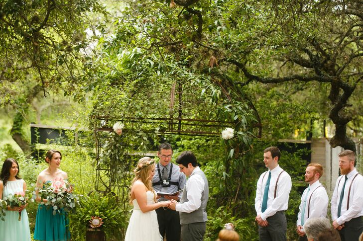 Mindy and Marcus exchanged vows under a wrought iron wedding arch draped in vines, greenery and soft pink and white blooms. The aisles were lined with with cedar and topped with mason jars of flowers and eucalyptus.
