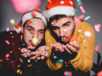 same sex couple blowing Christmas confetti
