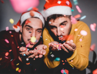 same sex couple blowing Christmas confetti