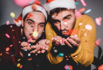 same sex couple blowing Christmas confetti