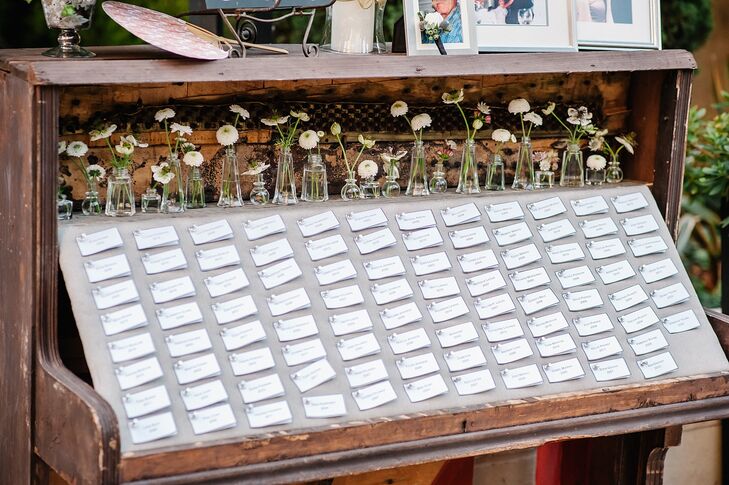 The couple pinned traditional escort cards to a board laid over a repurposed wooden piano.