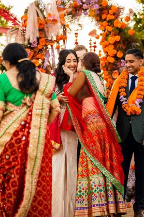 Family Member in Sari Kisses Bride on Cheek During Colorful Indian-Persian Fusion Wedding Ceremony