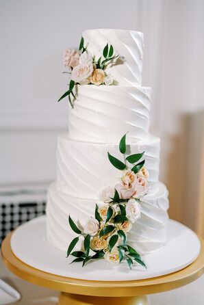 Four-Tier White Wedding Cake With Frosting Ridges and Fresh, Neutral Flowers