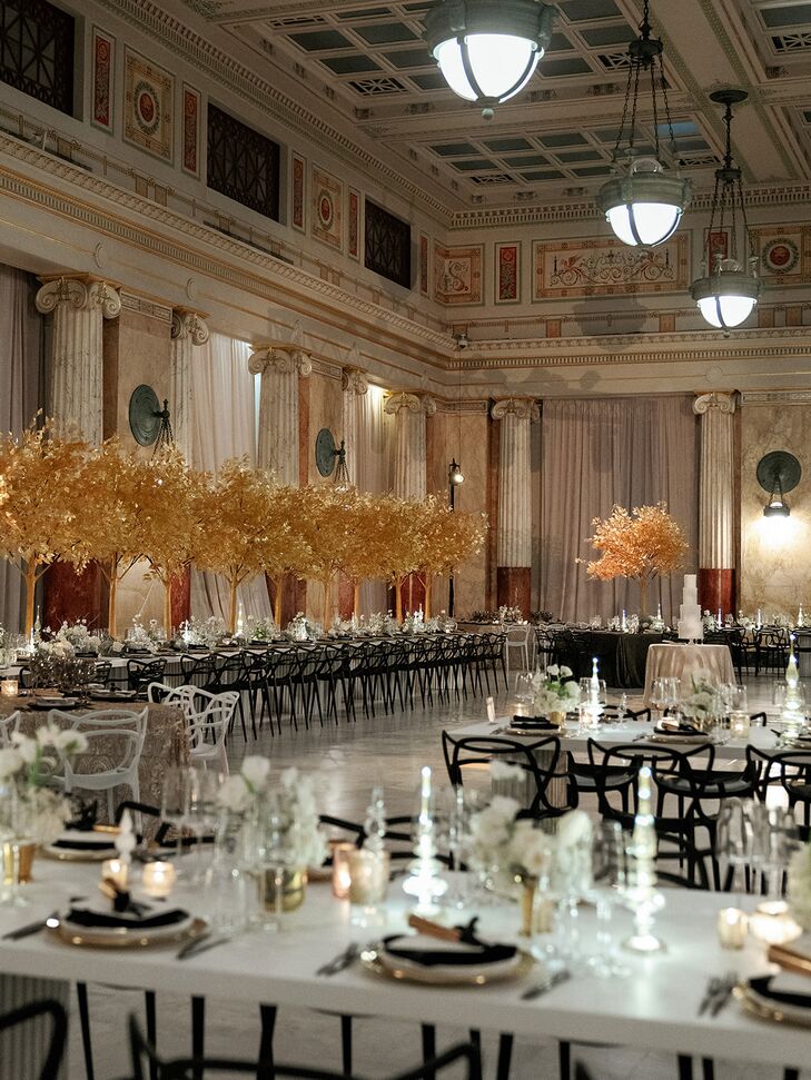 The couple's goal for the decor was "fun, flirty, bold and glam-centric," so they opted for these tall, golden centerpieces and accents of black and white for their Union Station wedding.